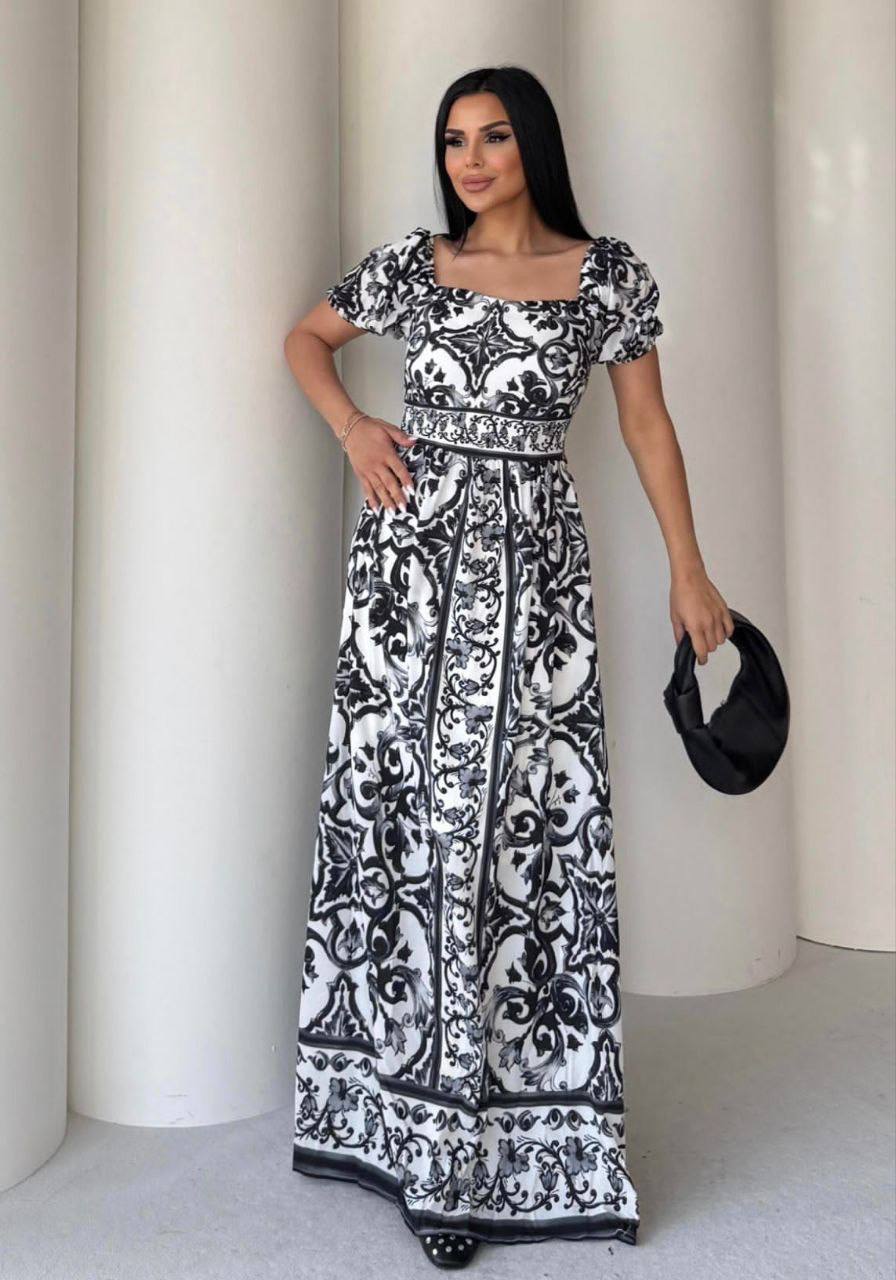 Woman wearing a black and white patterned dress against a white background