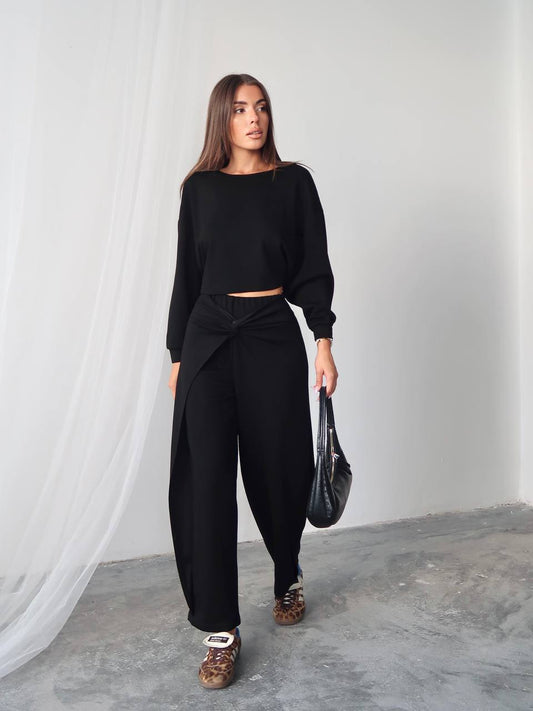 Woman wearing a black outfit with a plain background