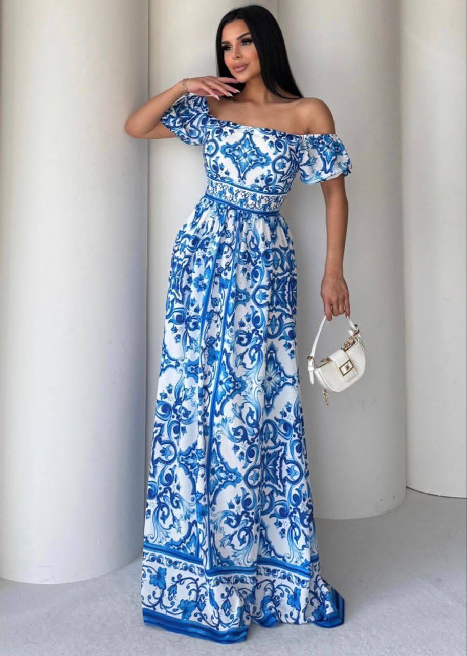 Woman wearing a blue and white patterned dress against a plain background