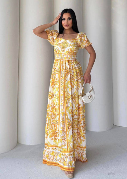 Woman wearing a yellow and white patterned dress against a white background